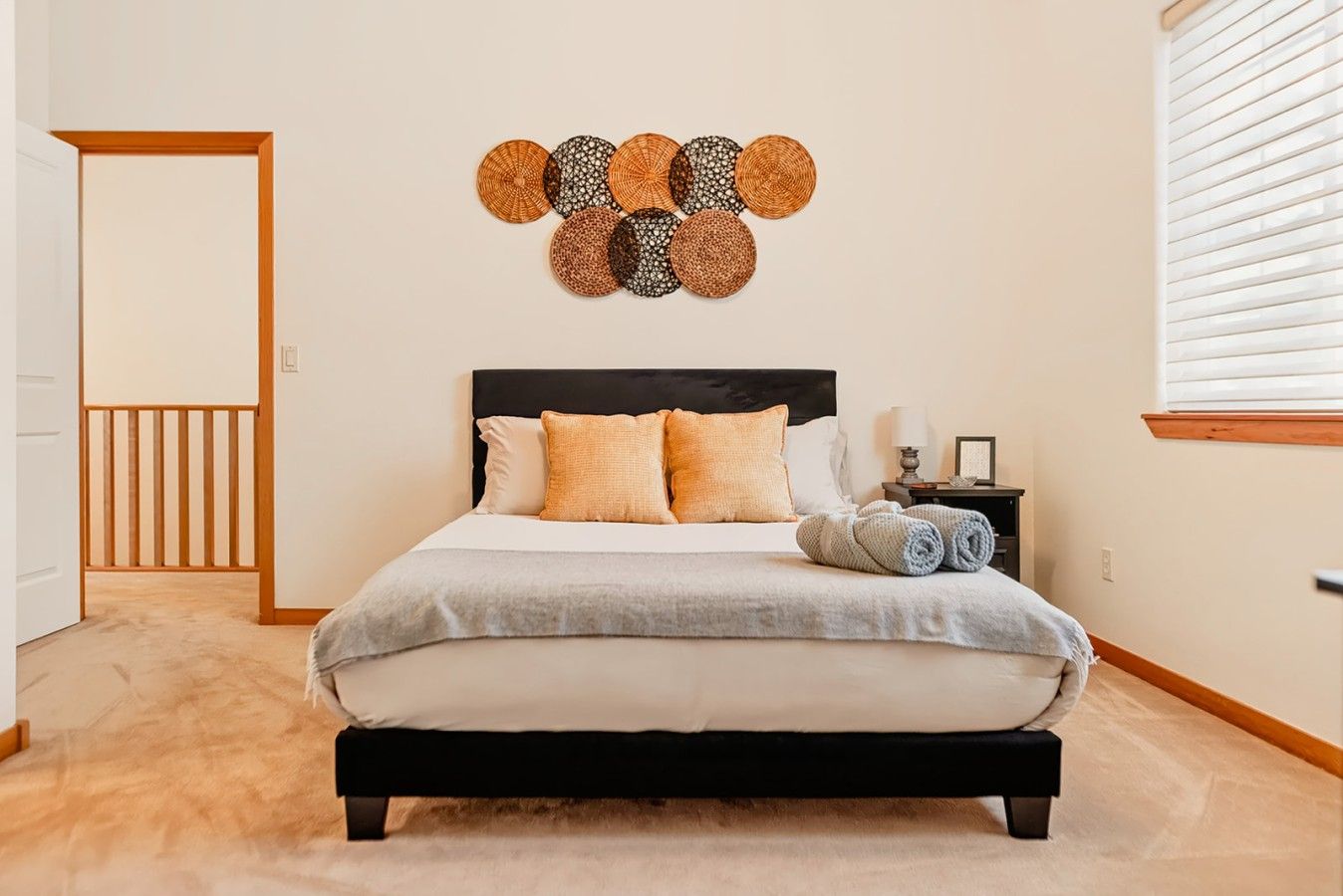 Une chambre à coucher avec un lit, des oreillers, une table de chevet, une lampe et un élément décoratif mural.