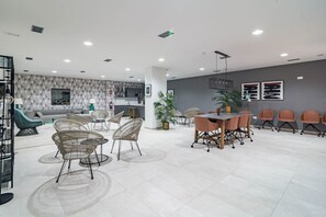 A spacious room with a dining area, seating arrangements, and a kitchen in the background. - Estepona Penthouse, Hot Tub, Views Oasis325 (Málaga)