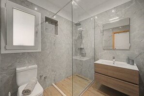 A modern bathroom with a toilet, shower, and vanity. - Apartment 'Angel' with Sea View, Wi-Fi and Air Conditioning (Σιδάρι)