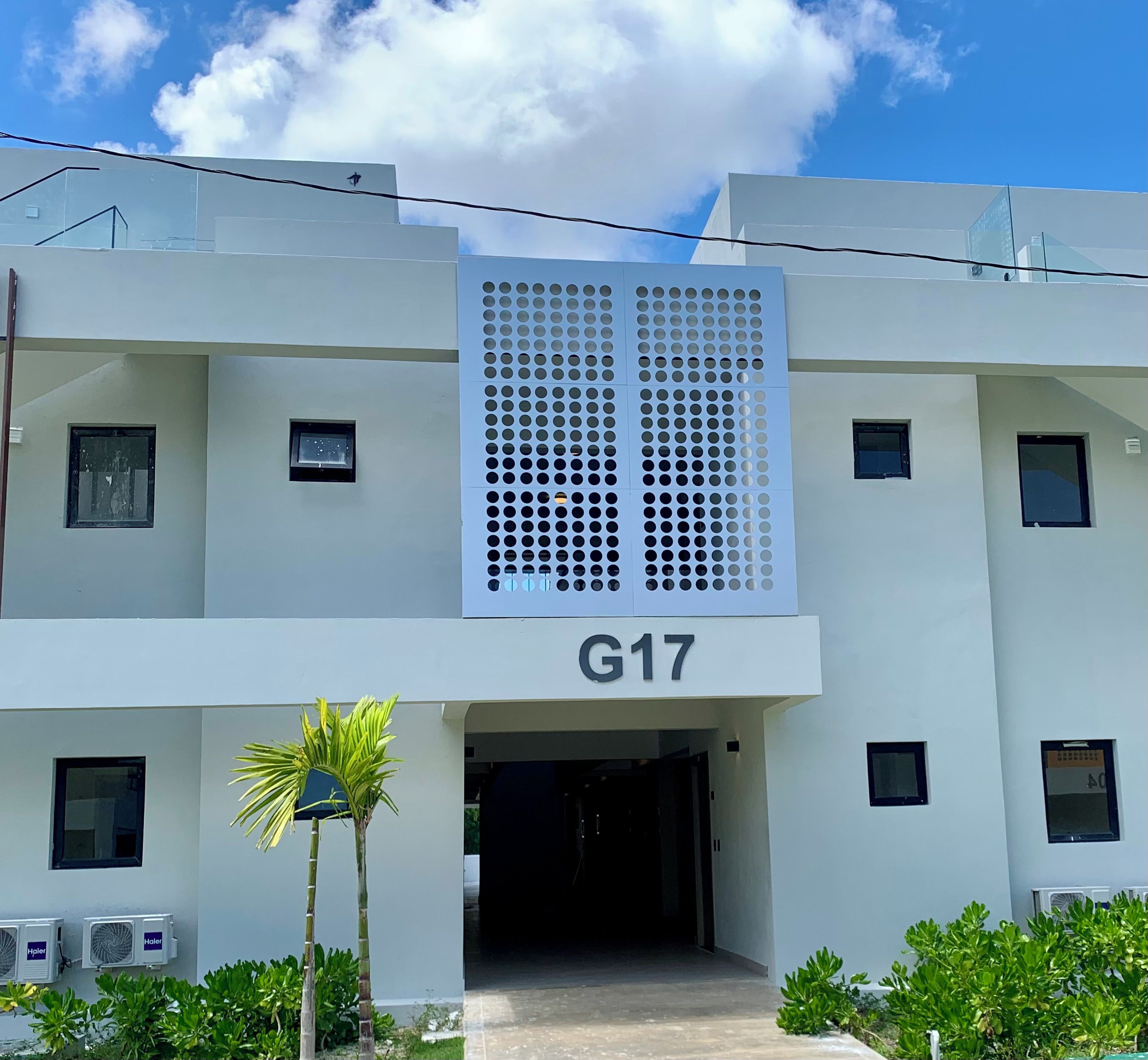 Ein modernes Gebäude mit einer flachen Fassade, zahlreichen Fenstern und einem Schild mit der Aufschrift 'G17'.