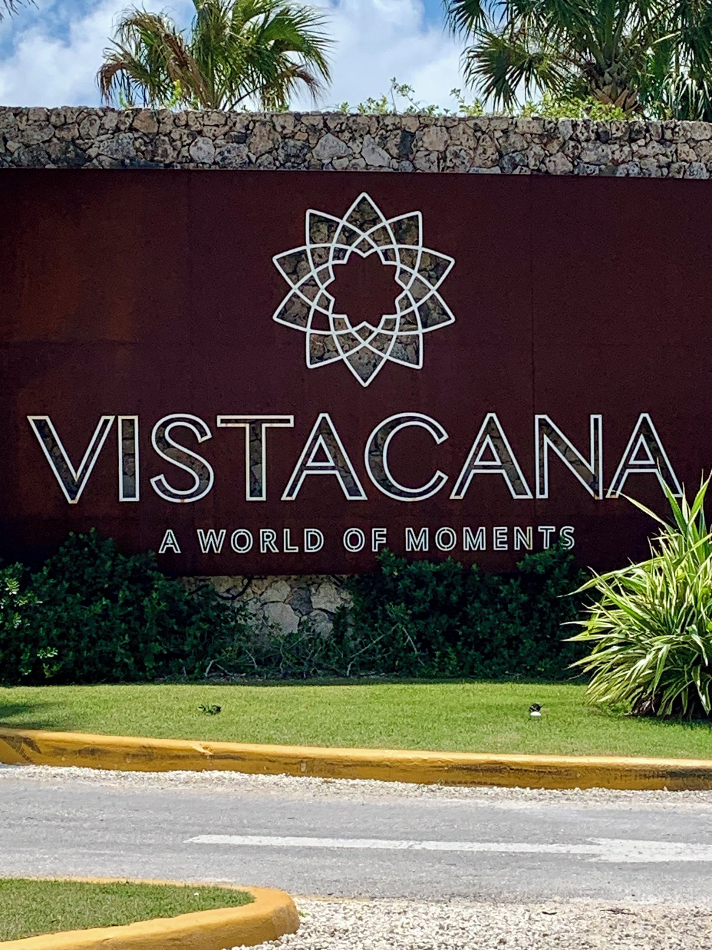 Ein Schild mit dem Text 'VISTACANA A WORLD OF MOMENTS' und einem geometrischen Logo.