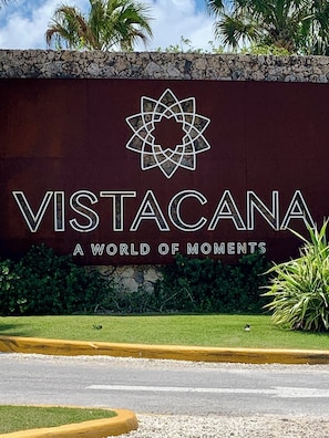 Ein Schild mit dem Text 'VISTACANA A WORLD OF MOMENTS' und einem geometrischen Logo.