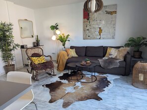A living room with a sofa, a coffee table, a chair, and a cowhide rug. - Sea-View Apartment, Walk to Beach, Estepona (Estepona)