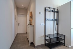 A hallway with a coat rack, a small table, and a door. - RG133 - Spacious 3 bed apartment in prime location (Marbella)