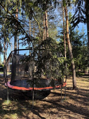A trampoline in a wooded area with trees and a clear sky. - Modern Barn with SPA, 5 km from Zegrze Reservoir (Beniaminów)