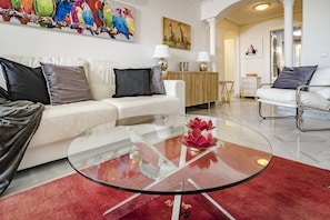 A modern living room with a glass coffee table, a white sofa, and a red rug. - SAA2- comfortable apartment Puerto banus (Marbella)