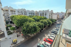 A street lined with parked cars and trees, with buildings in the background. - New modern apt, rooftop pool, Estepona - zaga3c (Estepona)