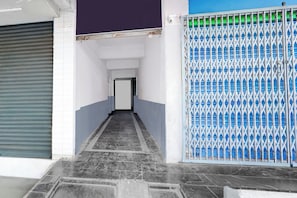 A corridor with a tiled floor leading to a closed door. - Hotel O Vijayawada Bus Terminal (Vijayawada)
