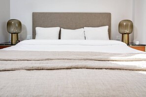 A neatly made bed with a beige headboard, two bedside lamps, and a white blanket. - TE- Luxury resort, front line beach, families only (La Gaspara)