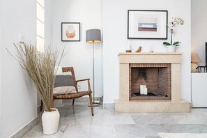A modern interior with a fireplace, a chair, and decorative items. - SAm24I- Cozy apartment walking distance to beach (Marbella)