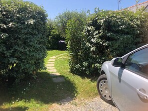 A gravel path leading through a garden area with dense foliage on either side. - Cottage 'Kêr Didrouz' with Private Terrace, Private Garden and Wi-Fi (Le Palais)