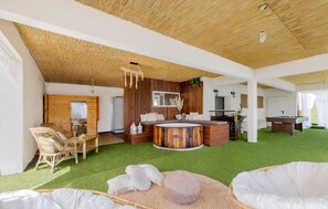 A spacious room with a pool table, a hot tub, and a dining area with wicker furniture. - Nice home in Jastrebarsko with sauna (Jastrebarsko)