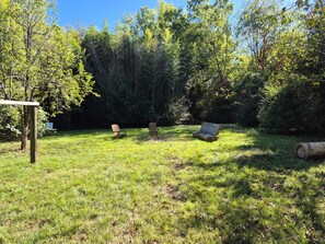 An outdoor area with a wooden bench, a picnic table, and a log. - Beautiful 2-bedroom house with huge fenced yard in delightful Chattanooga (Chattanooga)