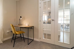 A room with a desk, chair, and a door leading to a dining area. - RDM9- Modern family apartment in Riviera del Mar (Mijas)