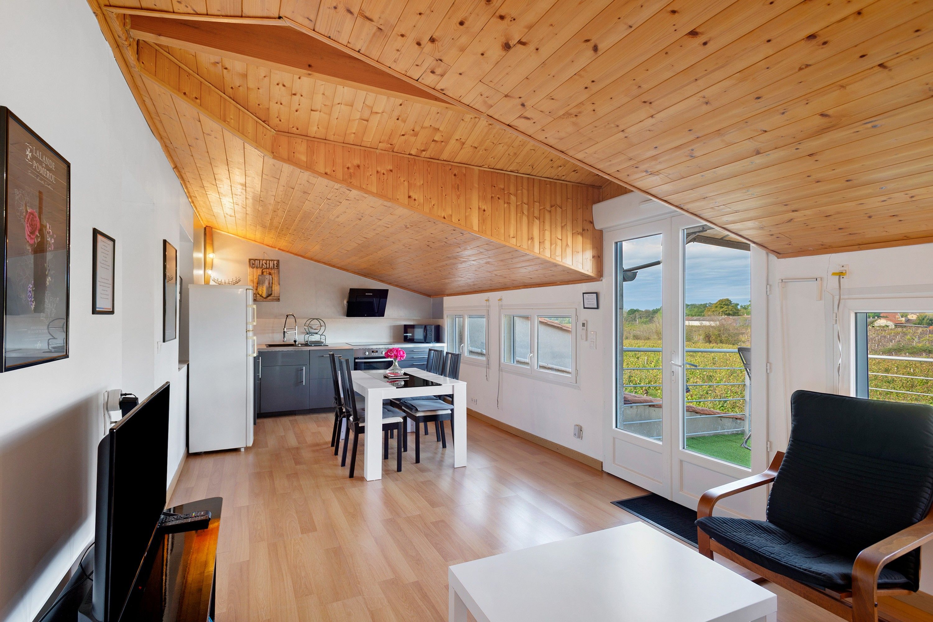 Eine moderne Küche mit Essbereich, Holzboden und großen Fenstern.