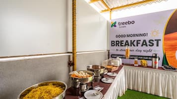 Een ontbijtbuffet met diverse gerechten en een banner voor Treebo Hotels.