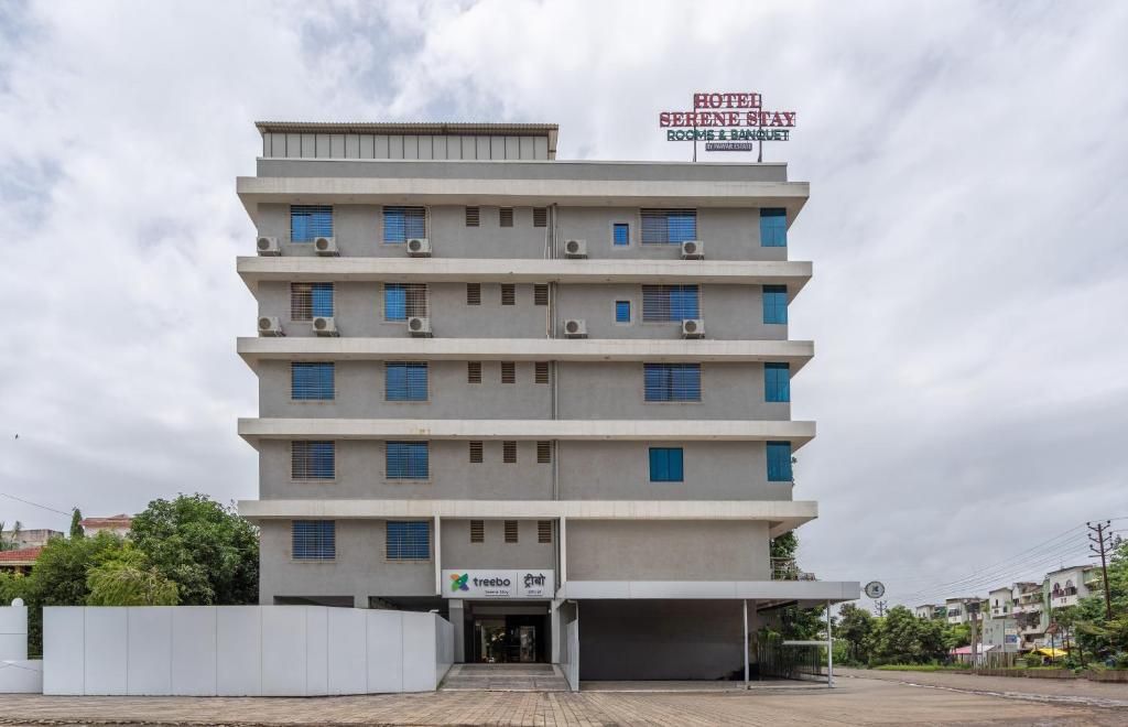 A multi-story hotel building with a sign indicating it is a hotel and a parking area.