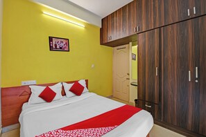 A bedroom with a bed, a wardrobe, a door, and a wall-mounted light fixture. - Hotel O Metro Inn Manyata (Bengaluru)