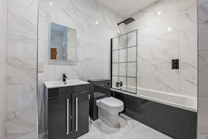 A modern bathroom with a shower, toilet, and sink. - Luxury 4 Bed | Jewellery Quarter | Private Parking (Birmingham)
