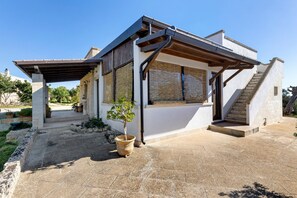 A modern house with a covered patio, a staircase, and a small garden area. - Apartment 'Borgo Ritrovato - Casa Ulivo' with Private Terrace, Wi-Fi and Air Conditioning (Patù)
