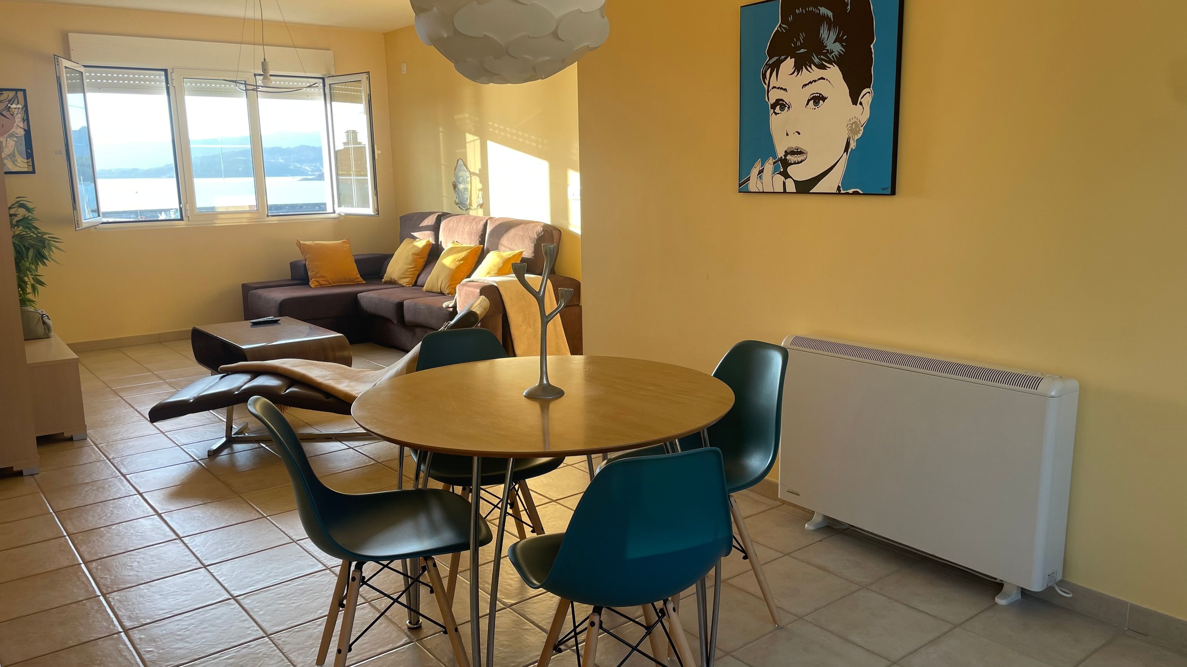 Un salon avec un canapé, des fauteuils, une table et un radiateur.