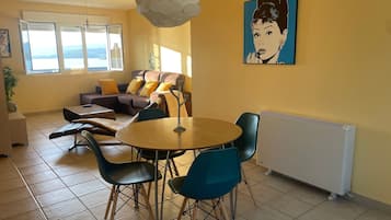 Un salon avec un canapé, des fauteuils, une table et un radiateur.