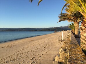 A beach with a clear sky, a rocky shoreline, and palm trees. - Holiday Home 'Casa vacacional' with Sea View and Terrace (Goyanes)