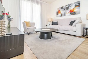 A modern living room with a round coffee table, a sofa, a chair, and a decorative vase. - ZAga2C - Brand New modern apartment 200m to beach (Estepona)