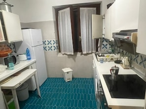 A compact kitchen with a microwave, a small sink, and a stove. - Villa 'Cosmi' with Relaxation and Panoramic View near La Pelosa (Stintino)