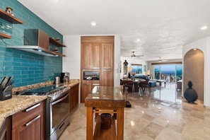 A modern kitchen with granite countertops, stainless steel appliances, and wooden cabinetry. - Stunning Ocean Views • 2BR above Zona Romantica (Puerto Vallarta)