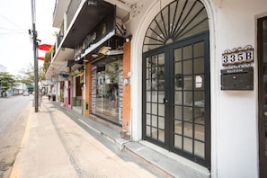 A street view with a row of storefronts, including a pharmacy and a vape shop. - Cozy Modern Condo Steps to Everything (Puerto Vallarta)