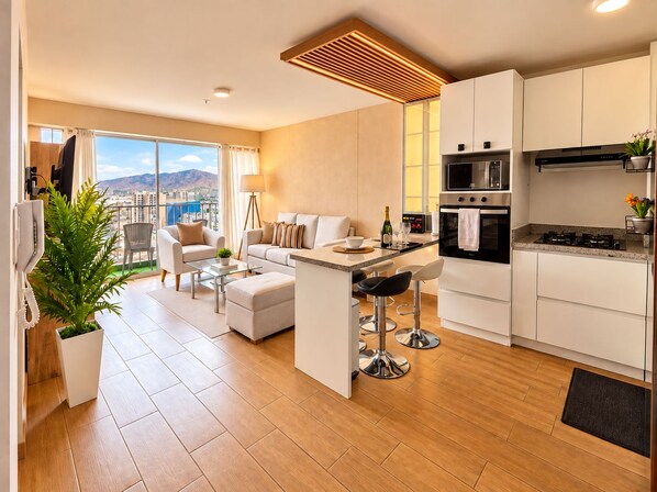 A modern apartment with a kitchen, dining area, and living room.