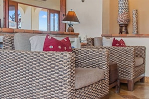 A seating area with patterned upholstery, a lamp, and a view of the outdoors. - Tranquil Two Bedroom Condo in Zona Romantica (Puerto Vallarta)