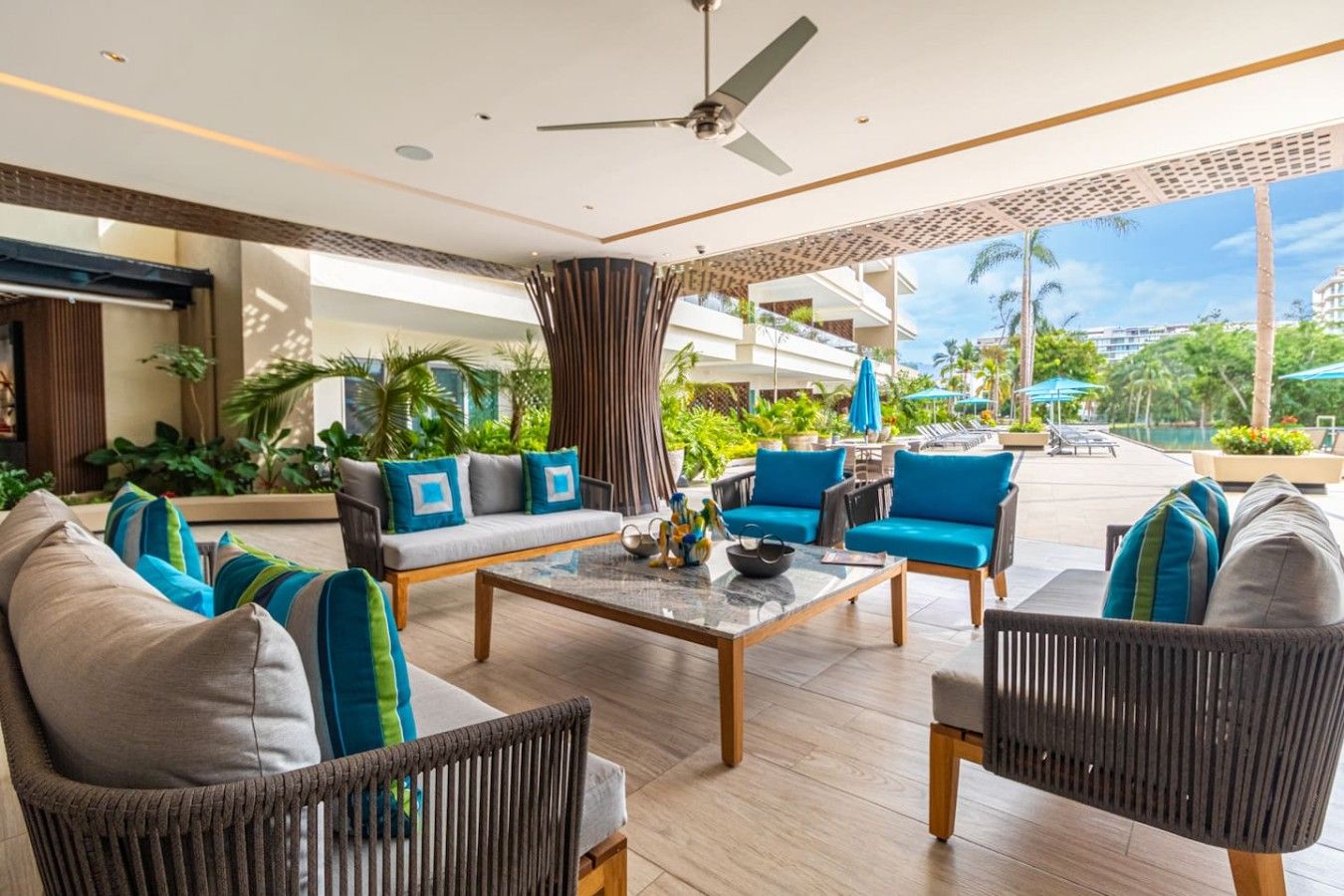 Un espace de détente extérieur moderne, comprenant des sièges, une table basse et un ventilateur de plafond.