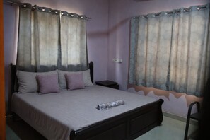 A bedroom with a bed, pillows, a nightstand, and curtains. - Serene 1BR 1BT Wi-Fi Kitchen Laundry TV Wardrobe (Ejisu)
