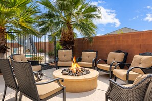 An outdoor seating area with wicker chairs and a central fire pit. - Grand Resort #98: Private Pool + Sports Court (Santa Clara)