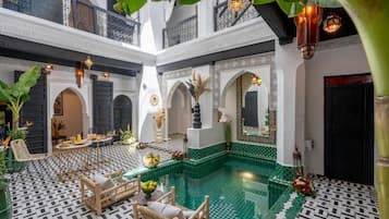 A courtyard with a swimming pool, seating area, and decorative elements.