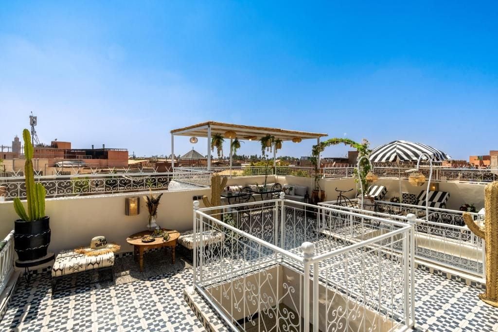A rooftop terrace with outdoor seating, a pergola, and a distinctive striped dome structure.