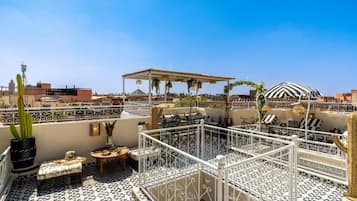 A rooftop terrace with outdoor seating, a pergola, and a distinctive striped dome structure.