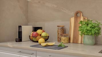 Un plan de travail de cuisine avec un panier de fruits, une planche à découper, une plante et un bocal.