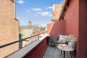 A balcony with a table, chairs, and a potted plant. - Lawendowa Old Town Signature Rooms with Shared Kitchen by Downtown Apartments (Gdańsk)