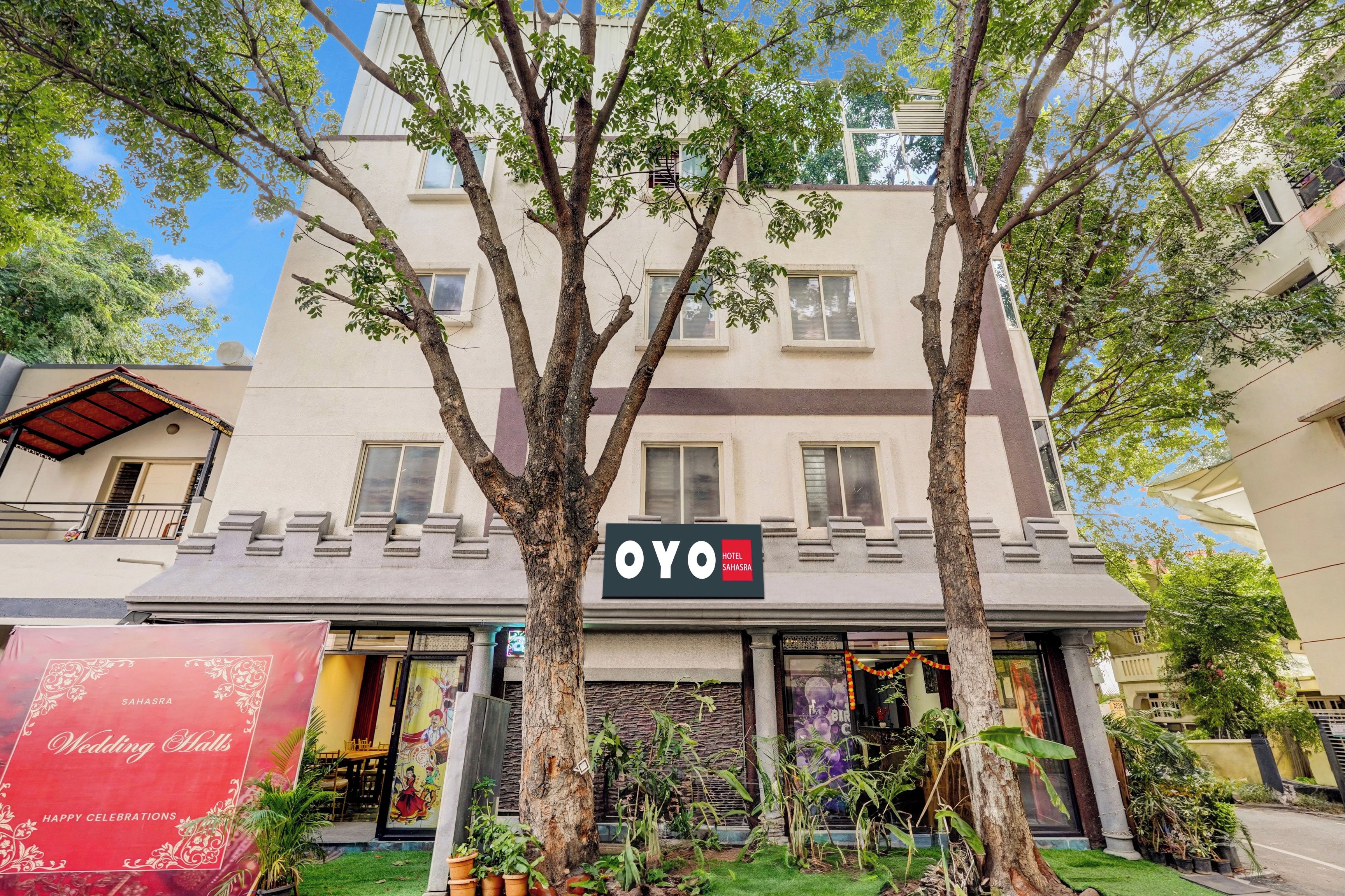 A hotel named 'OYO' with a modern facade, large windows, and a signboard.