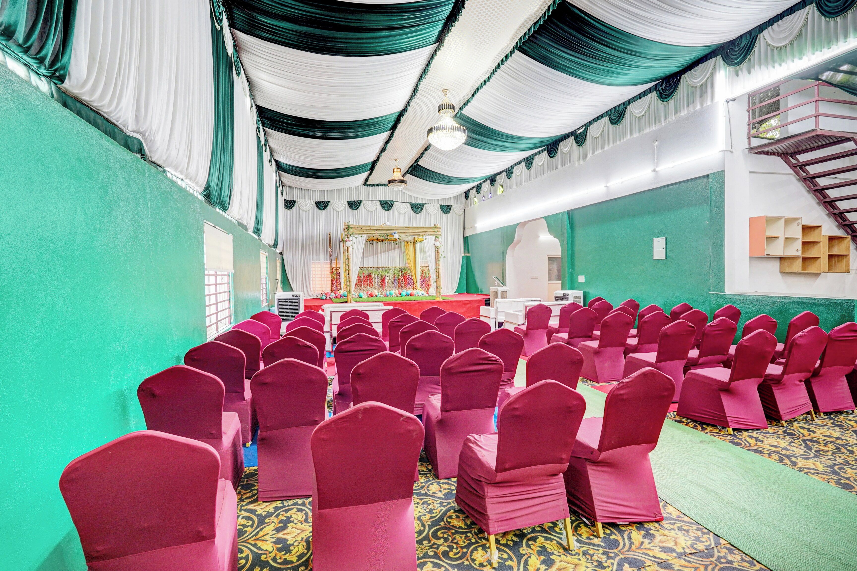 A hall with rows of chairs, a stage with a podium, and a staircase.