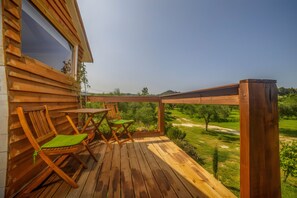 A wooden deck with a table and chairs, overlooking a green landscape. - Country House 'Terra Vine Collection - Green Leaf' with Wi-Fi and Air Conditioning (Αρκάδιοι)