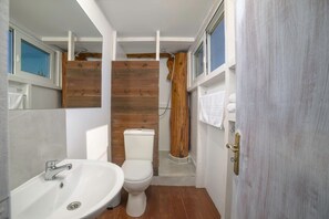 A bathroom with a white sink, toilet, and wooden accents. - Country House 'Terra Vine Collection - Green Leaf' with Wi-Fi and Air Conditioning (Αρκάδιοι)