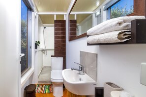 Ein kleines Badezimmer mit Toilette, Waschbecken und Dusche.