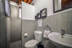 Ein Badezimmer mit Toilette, Waschbecken und Duschbereich.