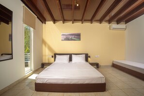 A hotel room with a large bed, a window, a wall-mounted air conditioner, and a picture of a dock. - Country House 'Terra Vine Collection - Raisin Hous' with Wi-Fi and Air Conditioning (Αρκάδιοι)