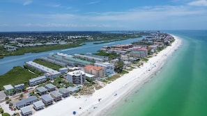 A coastal resort with beachfront properties, a marina, and a beach with umbrellas. - Fishing Pier | Heated Community Pool | Quick Walk to the Beach | Sea Shell #32 (Indian Shores)