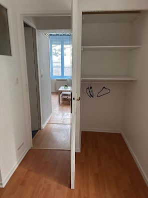 An interior space with a wooden floor, a white door, and a view of a room with a table and a window. - BELLAIR1: Business or leisure stay right across from the train station (Saint Dizier)